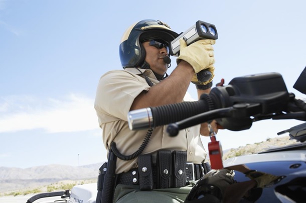 Traffic police officer looking through a radar gun
