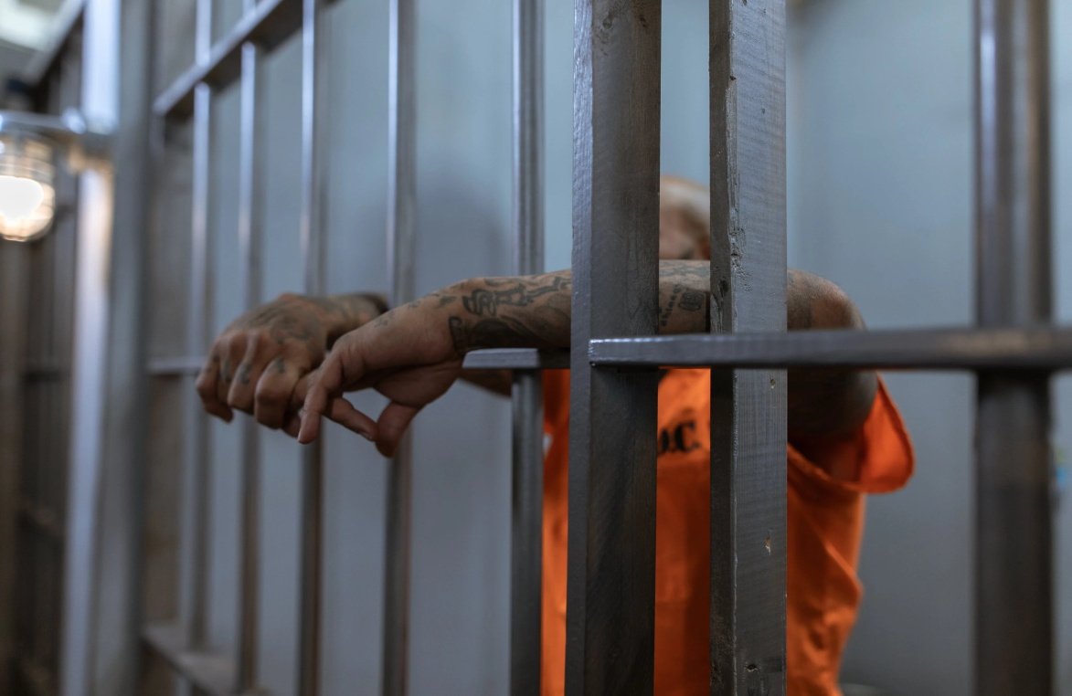 A criminal behind bars.