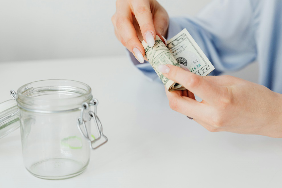 Woman rolling a wad of cash in her hands 