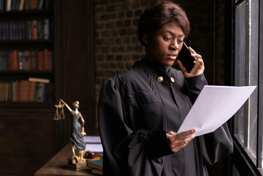 This image shows a judge reading a document while having a phone.