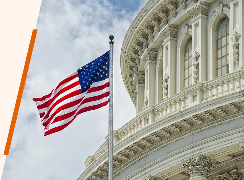 An American flag hoisted outside a white building.