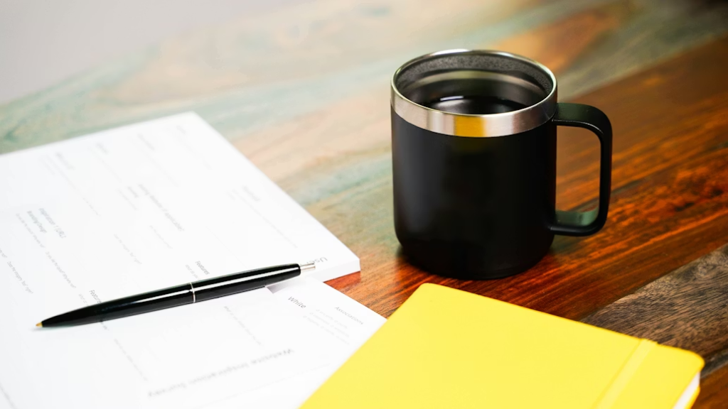 a coffee mug and a notebook on a table