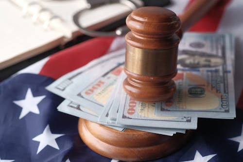 A wooden gavel on 100 US dollar banknotes on an American flag
