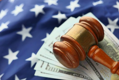 A wooden gavel on US dollars