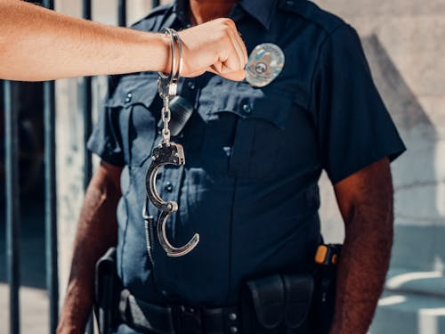 A person with one open handcuff