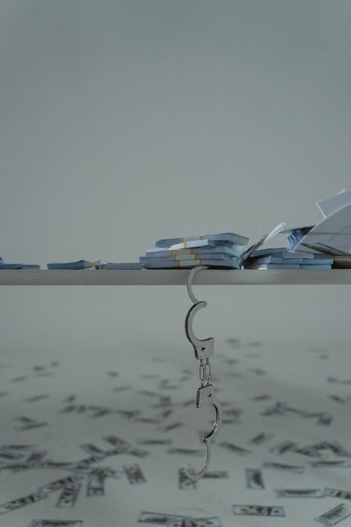 Bundles of cash on a wooden shelf representing bail bond payments